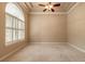 Spacious bedroom with neutral carpet, ceiling fan, and a large window with shutters at 15 Cambridge Trce, Ormond Beach, FL 32174