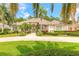 Charming home with a circular driveway, lush landscaping, and mature palm trees at 15 Cambridge Trce, Ormond Beach, FL 32174