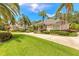Charming home with a circular driveway, lush landscaping, and mature palm trees at 15 Cambridge Trce, Ormond Beach, FL 32174