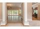 Spacious foyer with tile flooring, columns, and views to the living room at 15 Cambridge Trce, Ormond Beach, FL 32174