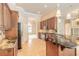 Well-equipped kitchen featuring wood cabinetry, stainless steel appliances, and a granite-topped island at 15 Cambridge Trce, Ormond Beach, FL 32174