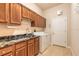 Well-equipped laundry room with wooden cabinets, granite counters, and modern washer and dryer at 15 Cambridge Trce, Ormond Beach, FL 32174