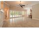 Spacious living area with tile floors, a ceiling fan, and multiple doors leading to the outdoor pool area at 15 Cambridge Trce, Ormond Beach, FL 32174