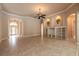 Expansive living area with elegant tile flooring, custom built-ins, and an arched doorway to the front entrance at 15 Cambridge Trce, Ormond Beach, FL 32174