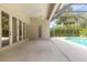 Large covered patio area with many doors to the backyard pool area at 15 Cambridge Trce, Ormond Beach, FL 32174