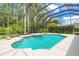 Pool with hot tub with screened in enclosure surrounded by lush green vegetation at 15 Cambridge Trce, Ormond Beach, FL 32174