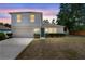 Charming two-story home with a well-maintained lawn, manicured shrubbery, and a two car garage at 1561 Randolph St, Deltona, FL 32725