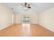 Empty living room with hardwood floors, neutral walls, ceiling fan, and sliding door to backyard at 1561 Randolph St, Deltona, FL 32725