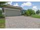Home featuring a paved driveway, a two-car garage, and professionally landscaped front yard at 1653 Victoria Gardens Dr, Deland, FL 32724