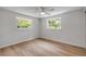 Bright bedroom boasts wood floors and two windows overlooking treed outdoor area at 173 Cedar Ave, Orange City, FL 32763