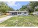 Inviting exterior view of the home featuring a covered porch, landscaped yard, and freshly painted exterior at 173 Cedar Ave, Orange City, FL 32763