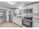 Modern kitchen boasts stainless steel appliances, white cabinets, and granite countertops at 173 Cedar Ave, Orange City, FL 32763