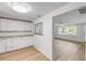 Bright kitchen features white cabinets, wood flooring, and a pass-through to the living room at 173 Cedar Ave, Orange City, FL 32763