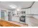 Updated kitchen with stainless appliances, white cabinets, and stone countertops at 173 Cedar Ave, Orange City, FL 32763