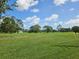 Expansive golf course view with green grass and scattered trees under a blue sky at 1730 Birmingham Ave, Daytona Beach, FL 32117