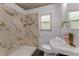Bathroom featuring faux marble wall, shower, and modern sink; provides a clean and refreshed design at 182 Grove St, Ormond Beach, FL 32174