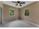 Bedroom featuring wood-look flooring, neutral walls, ceiling fan, and natural light from two windows at 182 Grove St, Ormond Beach, FL 32174
