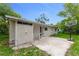 A single-story home with a unique storage area and a basketball hoop in the partially shaded backyard at 182 Grove St, Ormond Beach, FL 32174