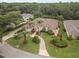 Aerial view of home with lush landscaping, circular driveway, and mature trees at 19 Tomoka Cove Way, Ormond Beach, FL 32174