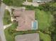 Aerial view of home featuring a pristine pool, verdant landscaping, and tile roof at 19 Tomoka Cove Way, Ormond Beach, FL 32174
