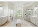 Bright bathroom with tiled floor, separate tub and shower, and and sinks at 19 Tomoka Cove Way, Ormond Beach, FL 32174