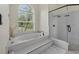 Bright bathroom featuring a soaking tub, walk-in shower, and large window at 19 Tomoka Cove Way, Ormond Beach, FL 32174