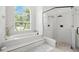This spa-like bathroom features a large walk-in shower, soaking tub, and a window for natural light and outdoor scenery at 19 Tomoka Cove Way, Ormond Beach, FL 32174
