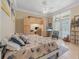 Cozy bedroom features a ceiling fan, a sitting area, and built-in shelving near the walk-out porch at 19 Tomoka Cove Way, Ormond Beach, FL 32174