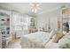 Bright bedroom with a desk and chair next to the window, and a bed with a blue floral pattern at 19 Tomoka Cove Way, Ormond Beach, FL 32174