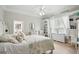 Coastal bedroom featuring a built-in desk, dresser, light ceiling fan and bright natural light at 19 Tomoka Cove Way, Ormond Beach, FL 32174