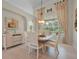 Dining room with a chandelier, neutral decor, and a large window offering views of the screened pool area at 19 Tomoka Cove Way, Ormond Beach, FL 32174