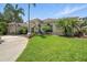 Front exterior showcases a home with manicured lawn, walkway, palm trees, and arched entryway at 19 Tomoka Cove Way, Ormond Beach, FL 32174