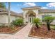 Inviting entryway featuring arched doorway and lush tropical landscaping at 19 Tomoka Cove Way, Ormond Beach, FL 32174