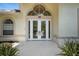 Elegant double front doors with decorative glass detailing and an arched transom window above at 19 Tomoka Cove Way, Ormond Beach, FL 32174