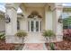 Stately home entry with grand doors, elegant lighting, and manicured planters at 19 Tomoka Cove Way, Ormond Beach, FL 32174