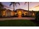 Charming home featuring decorative front doors with arched window and manicured landscaping at dusk at 19 Tomoka Cove Way, Ormond Beach, FL 32174