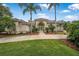Stunning Mediterranean-style home with tile roof, beautiful landscaping, and palm tree-lined front yard at 19 Tomoka Cove Way, Ormond Beach, FL 32174