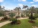 Beautiful landscaped front yard with lush green grass and palm trees, creating a tropical oasis at 19 Tomoka Cove Way, Ormond Beach, FL 32174