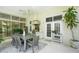 Covered lanai with gray table and chairs, built-in grill, and view of garden at 19 Tomoka Cove Way, Ormond Beach, FL 32174