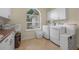 Bright laundry room with lots of counter space, shelving, and energy-efficient washer and dryer at 19 Tomoka Cove Way, Ormond Beach, FL 32174