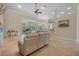 Bright living room with neutral tones, a ceiling fan, and sliding glass doors to the screened pool area at 19 Tomoka Cove Way, Ormond Beach, FL 32174