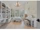 Bright main bedroom with hardwood floors, built-in shelving, a piano, and a window bench offers an inviting space at 19 Tomoka Cove Way, Ormond Beach, FL 32174