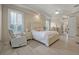 Relaxing main bedroom featuring tray ceilings, plantation shutters and a sitting area at 19 Tomoka Cove Way, Ormond Beach, FL 32174