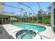 Screened pool and spa featuring a spacious patio with lush greenery surrounding the area at 19 Tomoka Cove Way, Ormond Beach, FL 32174