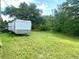 Sprawling backyard with lush greenery, a trailer, and ample space at 19320 Oberly Pkwy, Orlando, FL 32833
