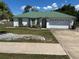 Charming single-story home with a well-manicured lawn, attractive landscaping, and a green metal roof at 1973 S Old Mill Dr, Deltona, FL 32725