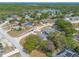 Aerial view of a neighborhood with many homes, lush greenery, and a lake in the distance at 198 Heather Lane Dr, Deltona, FL 32738