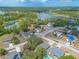 Aerial view of a neighborhood with many homes, lush greenery, and a lake in the distance at 198 Heather Lane Dr, Deltona, FL 32738