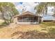 The backyard features a screened-in lanai with chairs and faces a fence separating neighboring properties at 198 Heather Lane Dr, Deltona, FL 32738