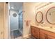 Bathroom with double sinks, wood cabinets, and glass shower with a tiled backsplash at 198 Heather Lane Dr, Deltona, FL 32738